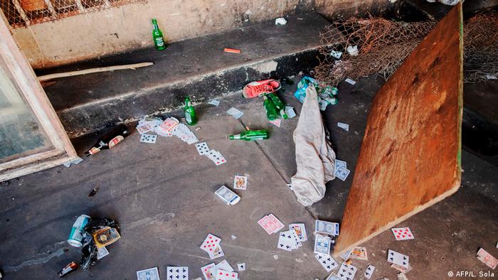 Beer bottles and playing cards scattered on the ground (AFP/L. Sola)