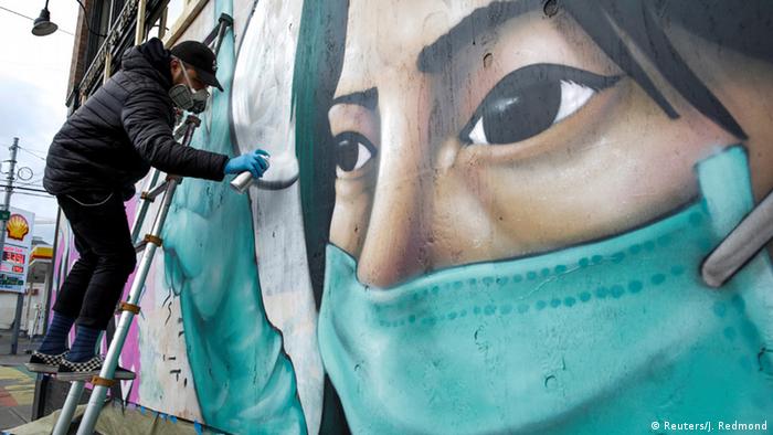 An artist in Seattle paints a mural depicting a health worker (Reuters/J. Redmond)