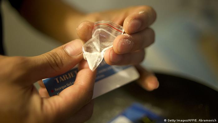 A person holds a tiny bag of cocaine (Getty Images/AFP/E. Abramovich)
