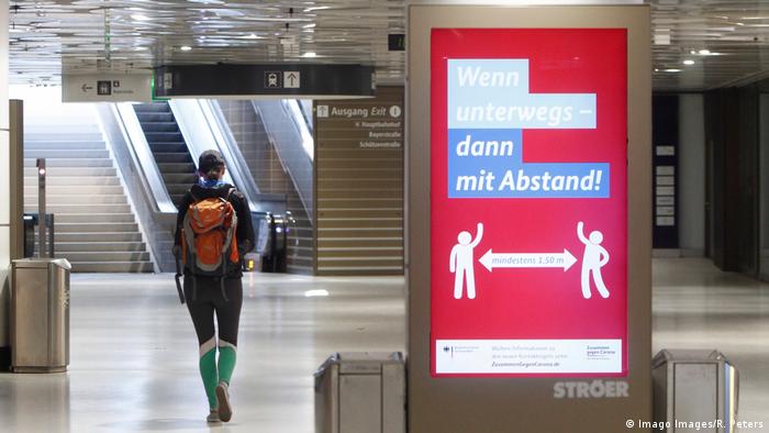 Cartel iluminado en Múnich, Alemania, que indica que se debe mantener distancia al caminar en espacios públicos.