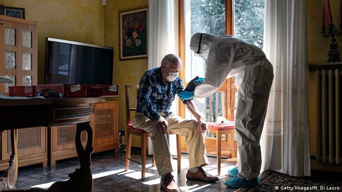 A member of the Italian Red Cross visits a patient at home in Bergamo, Italy