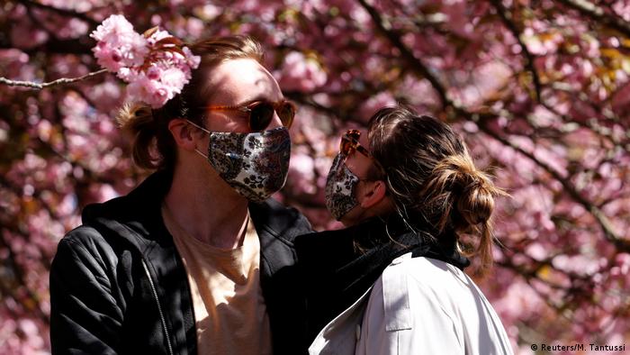 Влюбленная пара на фоне цветущей сакуры в Берлине