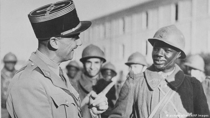 A historical photo showing a French officer speaking with a Senegalese soldier 