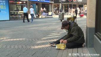 Бездомный в Кельне ест из картонной коробки
