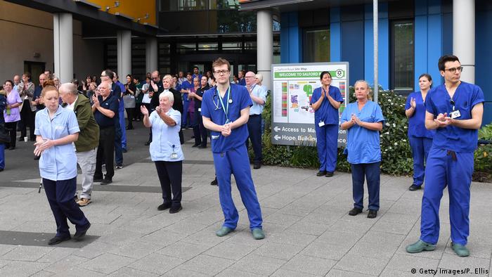 NHS workers observing a minute's silence outside Salford Royal Hospital