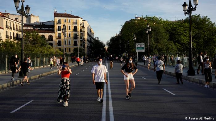 People walk and exercise on a street in Madrid, Spain.