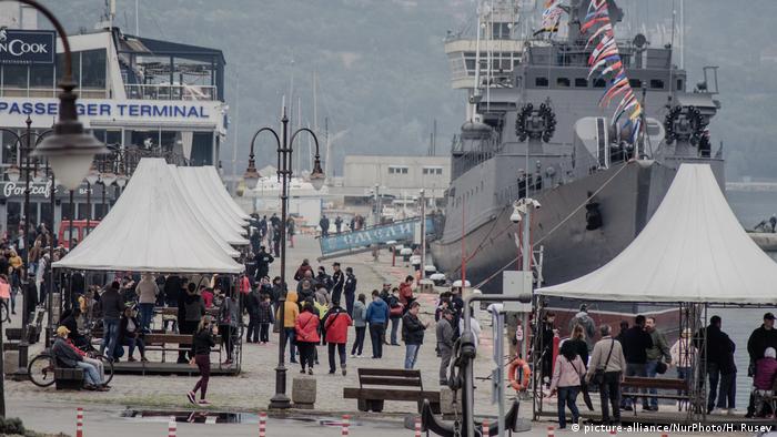People walk past a Navy ship docked in Varna (picture-alliance/NurPhoto/H. Rusev)