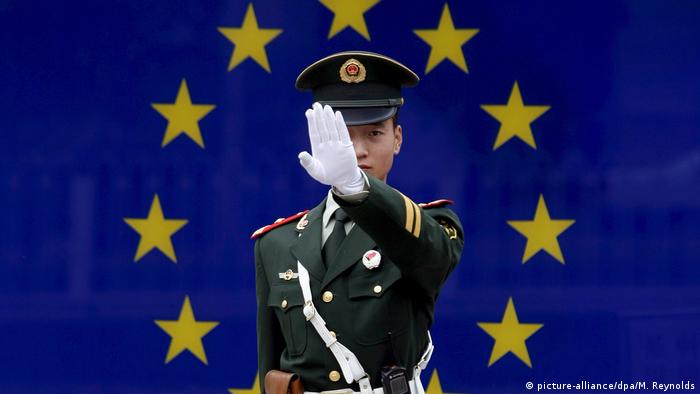 A Chinese police officer in front of an EU flag