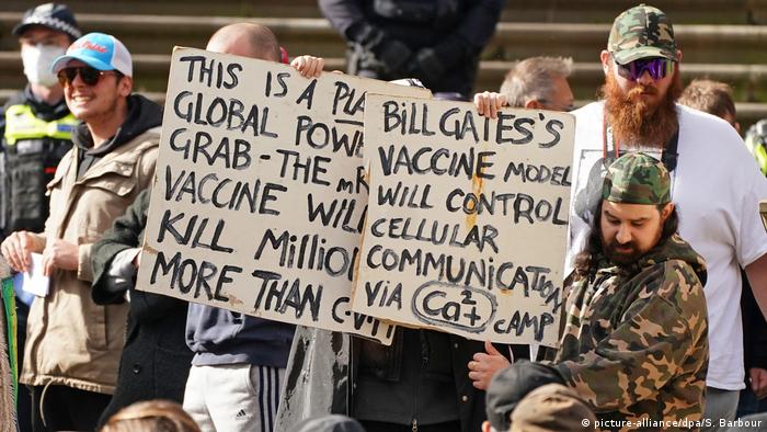 Anti-vaxxer protesters in Melbourne hold up a sign blaming Bill Gates