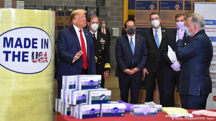 Of six people pictured, only US President Donald Trump does not wear a mask at a mask-making factory (Getty Images/AFP/M. Ngan)