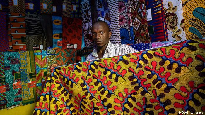 A man holds a traditional Ivorian wax print fabric