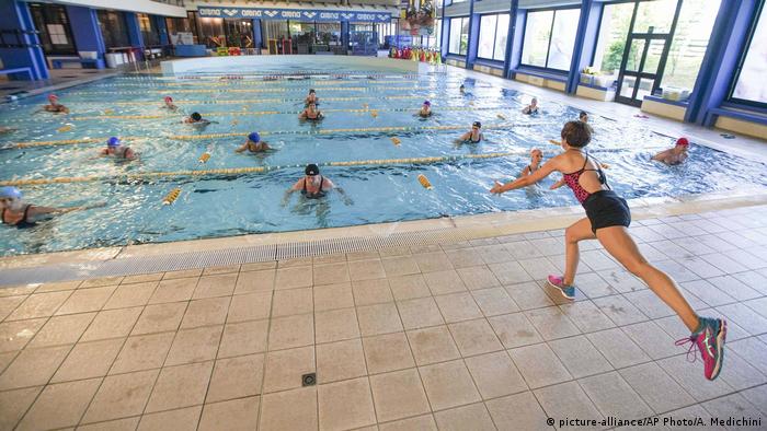 An instructor conducts a water gym lesson in the indoor swimming pool of the Forum sports center (picture-alliance/AP Photo/A. Medichini)