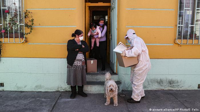 Un trabajador de la ciudad entrega una caja de comida durante la cuarentena obligatoria ordenada por el gobierno, en Santiago, Chile (22.05.2020)