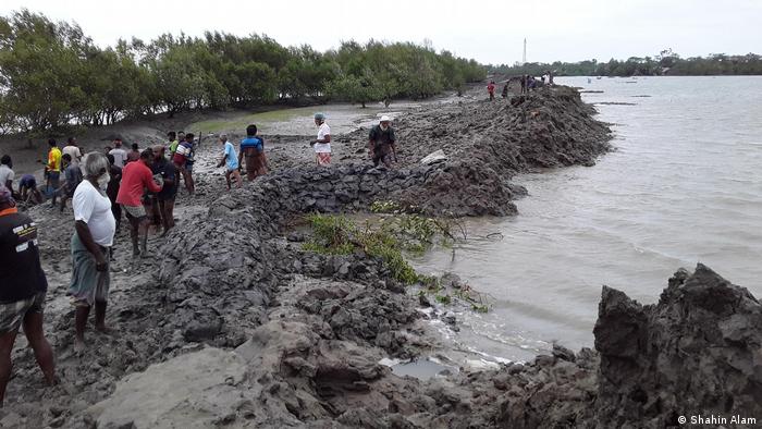 Villagers try to save the embankment during the high tide