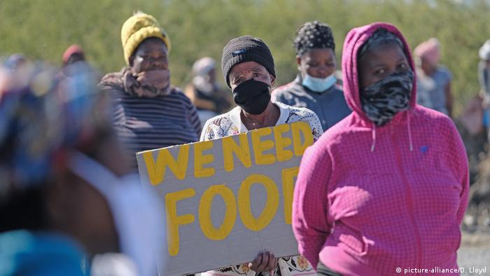A group of women hold a placard with the words: We need food (picture-alliance/D. Lloyd)