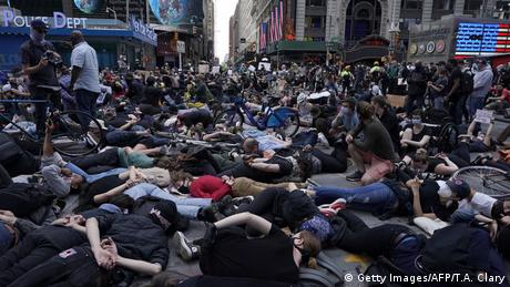 Protesters lay on the ground with their hands behind their back