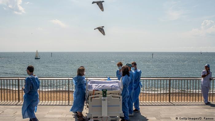 Un paciente es llevado cerca de la playa por personal de cuidados intensivos del Hospital del Mar, luego de estar hospitalizado desde el 9 de abril, Barcelona, España (03.06.2020)