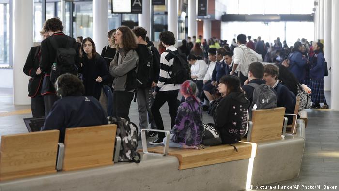 A crowd of people wait inside at a bus interchange in Christchurch, New Zealand