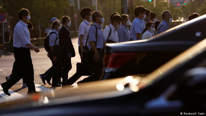 Workers in face masks walking outside in Tokyo (Reuters/I. Kato)