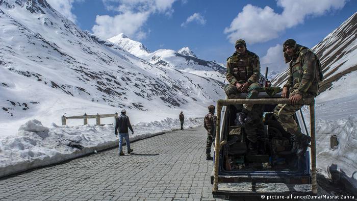Indian army trooper stands guards atop his vehicle the snow-cleared Srinagar-Leh highway