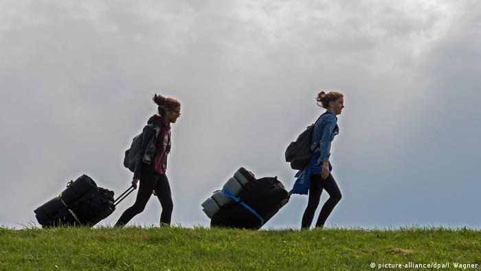 two young women with trolley bags on the island Spiekeroog, Germany (picture-alliance/dpa/I. Wagner)