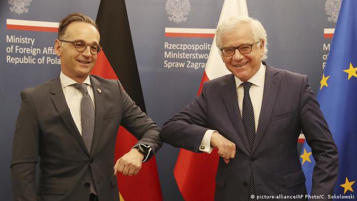 German Foreign Minister Heiko Maas,left, and Polish Foreign Minister Jacek Czaputowicz greet each other with an elbow bump, used instead of a handshake during the coronavirus pandemic, in Warsaw, Poland, Tuesday, June 16, 2020. (picture-alliance/AP Photo/C. Sokolowski)