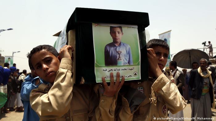 Boys carry the coffin of a child who died in Saudi airstrikes that hit passenger buses and killed dozens in August 2018