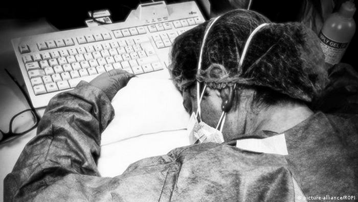 Enfermeira italiana Elena Pagliarini dorme sobre computador no trabalho