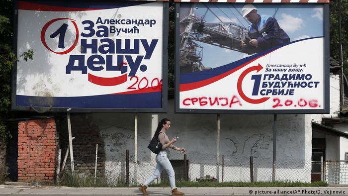Woman walking past election billboards (picture-alliance/AP Photo/D. Vojinovic)