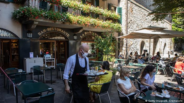 A waiter serves some customers at Bar Marianna in Bergamo