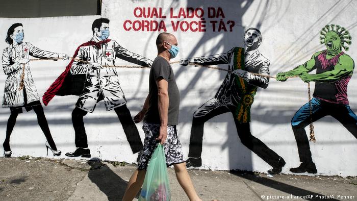 Coronavirus | Brasilien Wandgemälde mit Tauziehen zwischen Gesundheitspersonal Präsident Bolsonaro (picture-alliance/AP Photo/A. Penner)