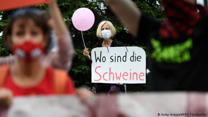 Protesters wave banners outside the slaughterhouse in Rheda-Wiedenbrück (Getty Images/AFP/I. Fassbender)