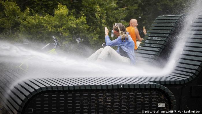 A woman is sprayed with water cannon (picture-alliance/ANP/R. Van Lonkhuijsen)