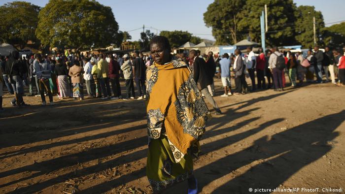 People stand in a line as they wait to vote in Malawi's elections.