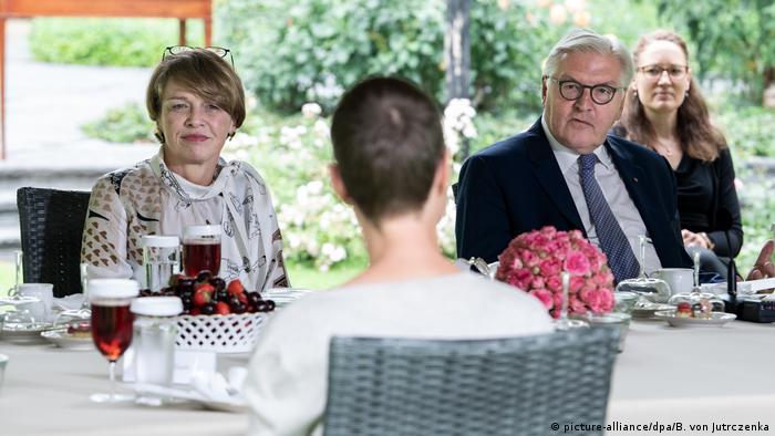 German president frank Walter Steinmeier sits outside at a table with his wife 