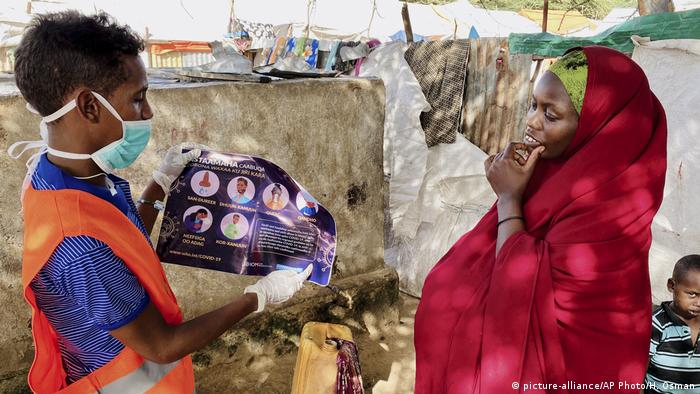 SA health worker explains to an internally-displaced Somali woman in Mogadishu how to protect herself from coronavirus (picture-alliance/AP Photo/H. Osman)