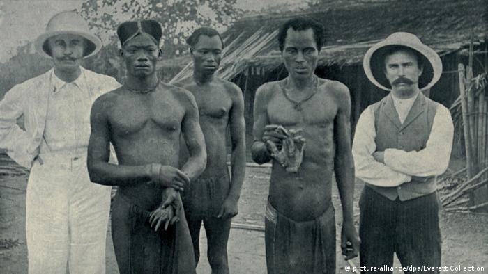 Two men hold the severed hands of their countrymen who were murdered by rubber sentries in 1904 in DR. 