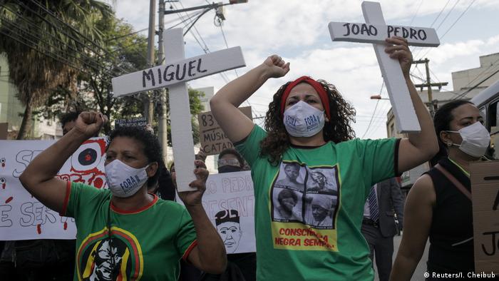 Demonstrators in Rio hold up signs protesting the killing of Joao Pedro (Reuters/I. Cheibub)