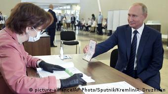 Ο Πούτιν δείχνει το διαβατήριό του προσερχόμενος στο εκλογικό τμήμα