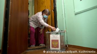 Μία γυναίκα ψηφίζει στην πόρτα του σπιτιού της στο Ιρκούτσκ της Σιβηρίας