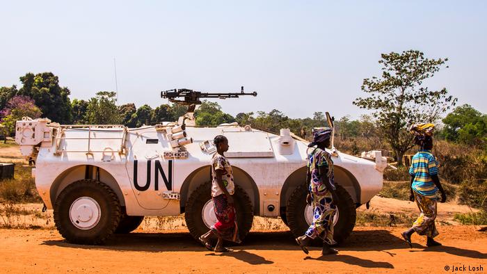Women walk past a UN armoured vehicle in rebel-held Kaga Bandoro (Jack Losh)