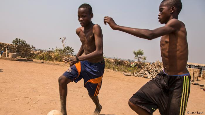 Teenage boys play football in the dust in Kaga Bandoro’s displacement camp (Jack Losh)