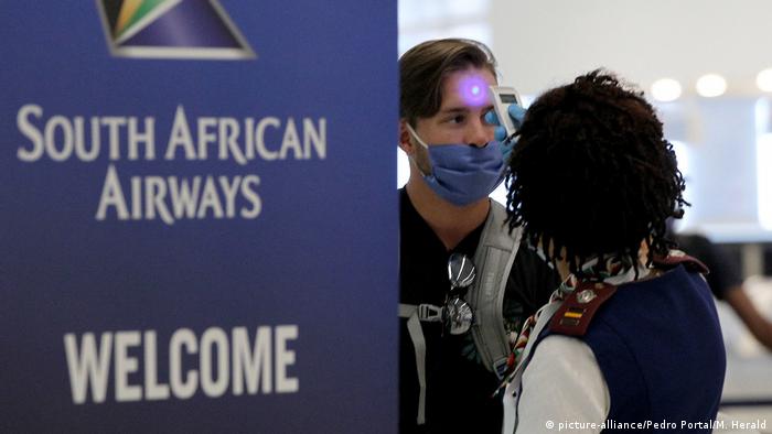A man has his temperature taken before boarding a South African Airways flight (picture-alliance/Pedro Portal/M. Herald)