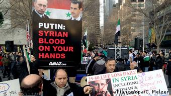 Демонстрация противников режима Асада, мужчина держит плакат Путин, сирийская кровь на твоих руках
