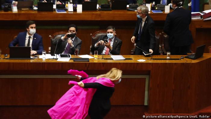 Pamela Jiles sprints in front of senior ministers in Chile wearing a pink cape (picture-alliance/dpa/Agencia Uno/L. Rubilar)