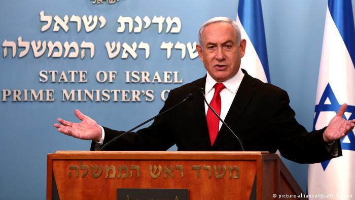 Benjamin Netanyahu speaks at a press conference from behind a podium