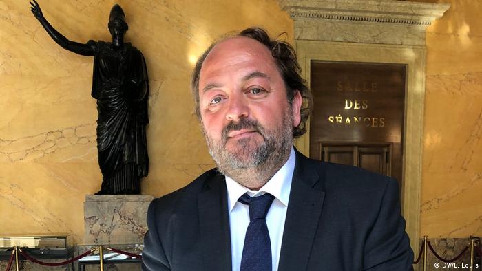 French politician Raphael Gauvin wears a shirt and tie and looks into the camera
