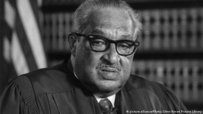 Thurgood Marshall, pictured wearing his judicial robes in front of a bookshelf