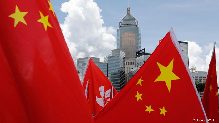 Buildings are seen above Hong Kong and Chinese flags, as pro-China supporters celebration after China's parliament passes national security law for Hong Kong, in Hong Kong