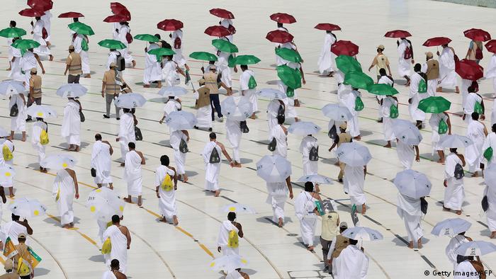 Pilgrims wearing white walk around the Kaaba